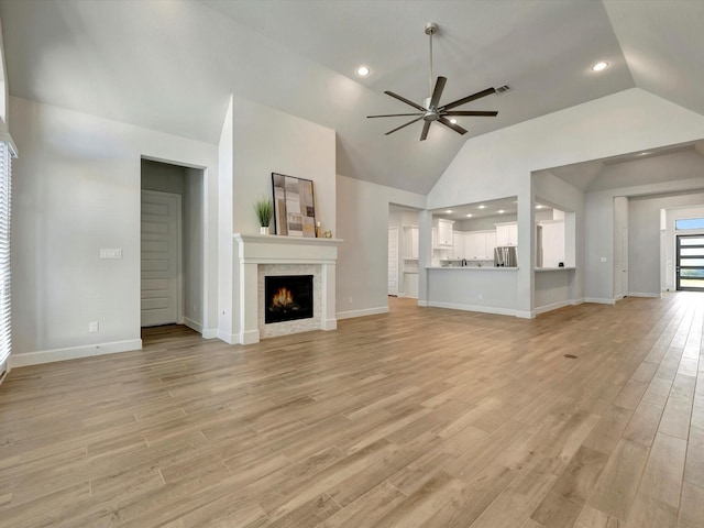 unfurnished living room with light wood-style flooring, recessed lighting, baseboards, ceiling fan, and a tile fireplace