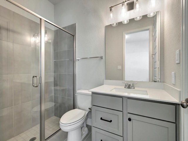 full bath with vanity, toilet, a textured wall, and a stall shower