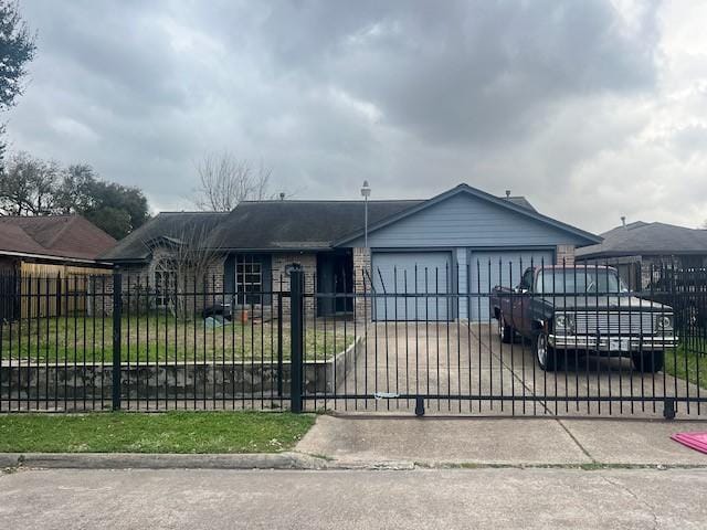 view of front of home featuring a fenced front yard, driveway, and a garage