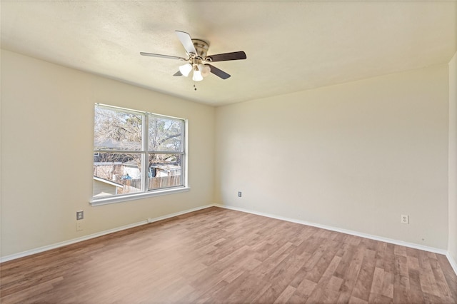 unfurnished room featuring ceiling fan, wood finished floors, and baseboards