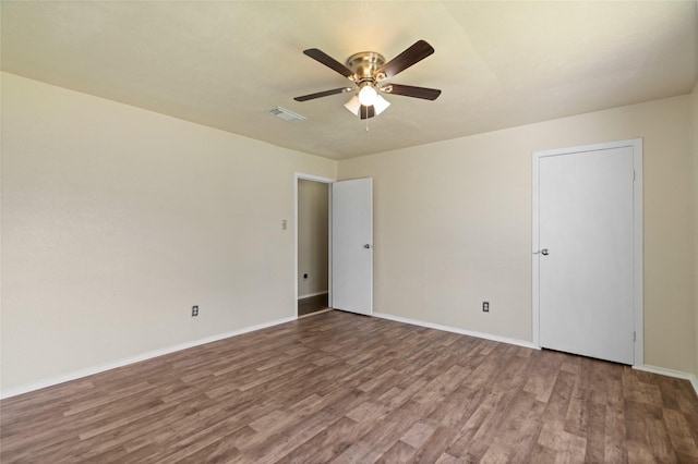 empty room featuring baseboards, visible vents, ceiling fan, and wood finished floors