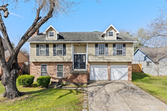 bi-level home with concrete driveway, an attached garage, fence, a front yard, and brick siding