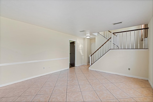 unfurnished room with baseboards, stairway, visible vents, and tile patterned floors