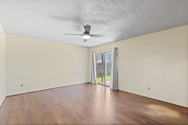 spare room featuring a textured ceiling, wood finished floors, a ceiling fan, and baseboards