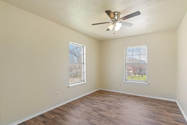 empty room featuring a ceiling fan, a textured ceiling, baseboards, and wood finished floors