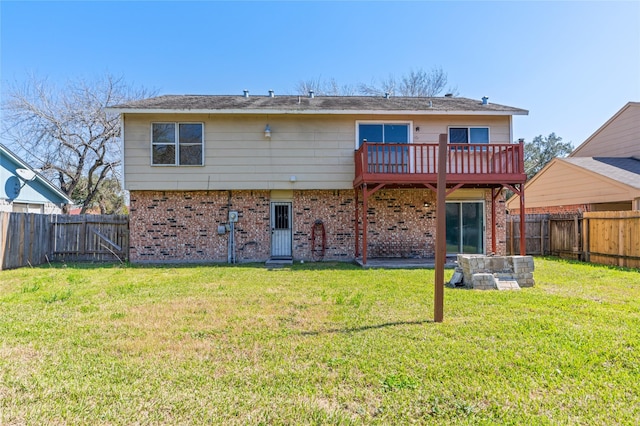 back of house with a fenced backyard, brick siding, and a lawn