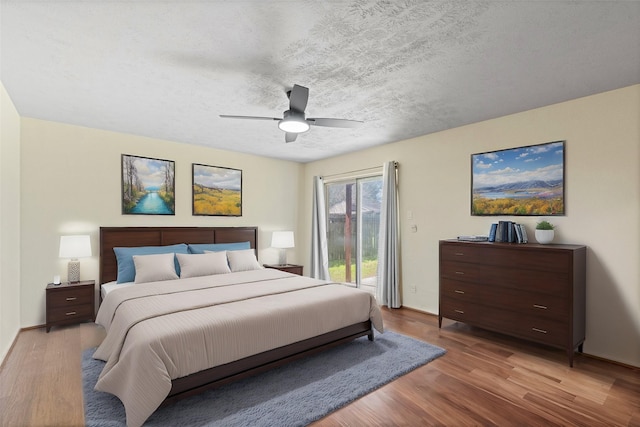 bedroom featuring a textured ceiling, ceiling fan, wood finished floors, and access to exterior