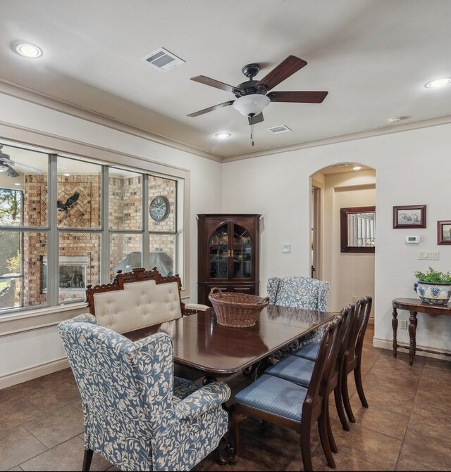 901 Longmire Rd Unit 17, Conroe, TX 77304 - tiled dining room with a ceiling fan, arched walkways, baseboards, recessed lighting, and crown molding
