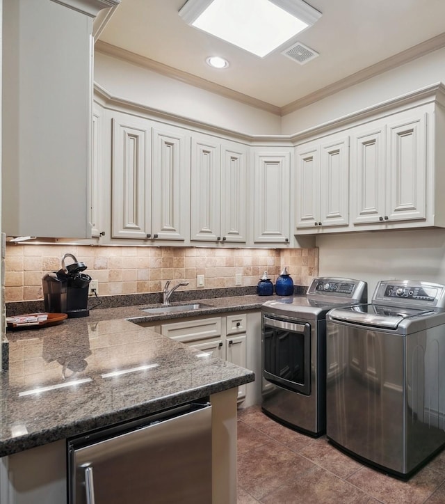 901 Longmire Rd Unit 17, Conroe, TX 77304 - washroom with washing machine and clothes dryer, recessed lighting, crown molding, and dark tile patterned flooring