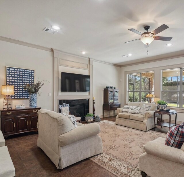 901 Longmire Rd Unit 17, Conroe, TX 77304 - living area with crown molding, a ceiling fan, dark tile patterned floors, a glass covered fireplace, and recessed lighting