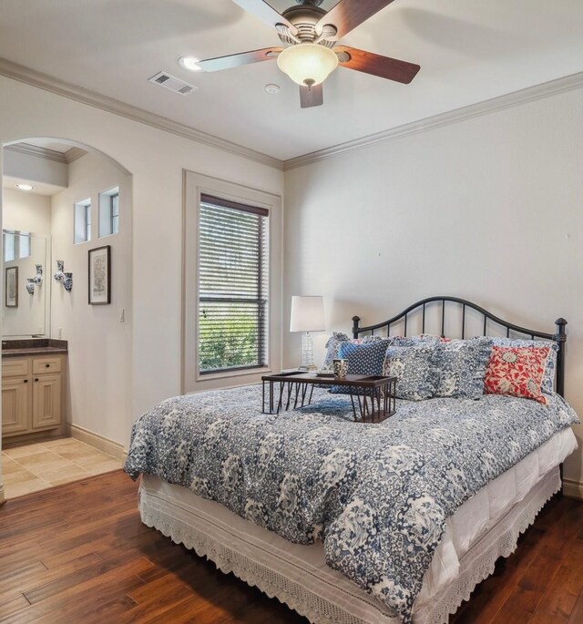 901 Longmire Rd Unit 17, Conroe, TX 77304 - bedroom with arched walkways, crown molding, light wood-style floors, baseboards, and a ceiling fan