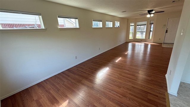 unfurnished room with ceiling fan, baseboards, and wood finished floors