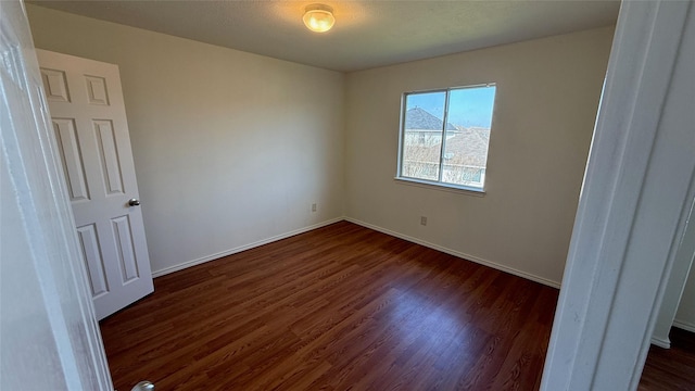 unfurnished bedroom with dark wood-style floors and baseboards