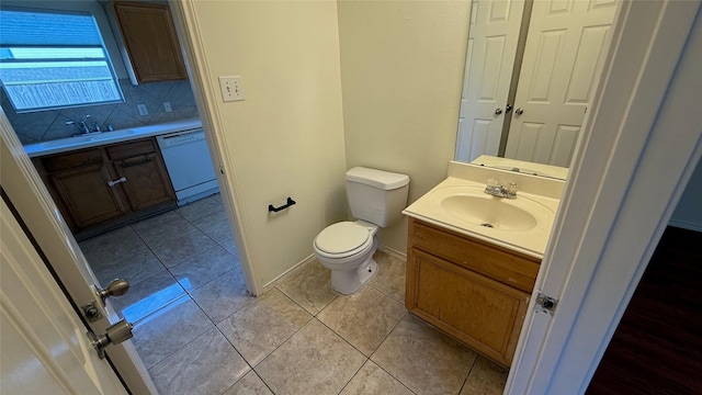 bathroom with decorative backsplash, toilet, vanity, baseboards, and tile patterned floors