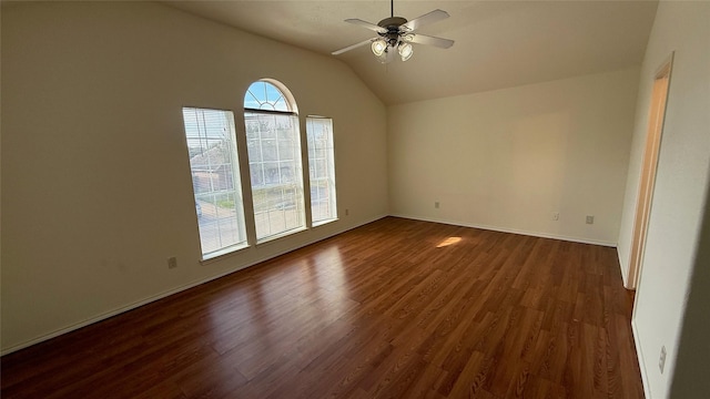 empty room with lofted ceiling, dark wood-style floors, baseboards, and a ceiling fan