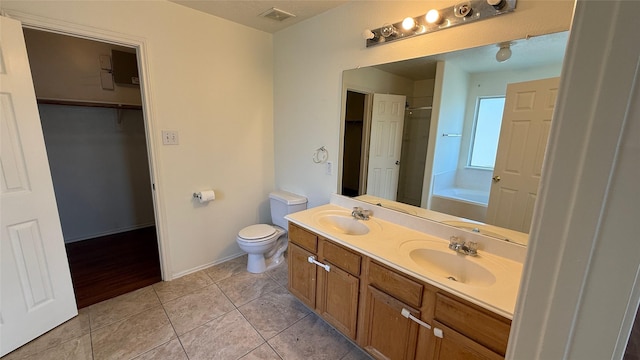 bathroom featuring a garden tub, tile patterned flooring, visible vents, and a sink