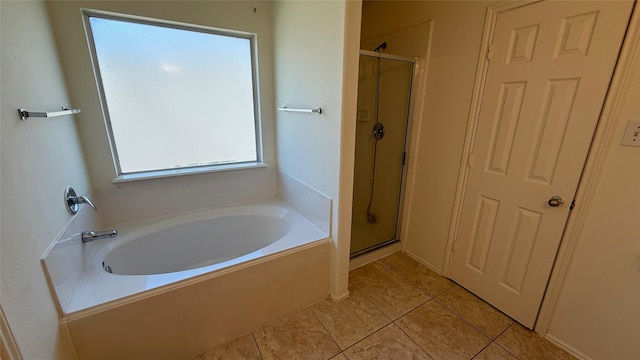 bathroom featuring a stall shower, plenty of natural light, a bath, and tile patterned floors