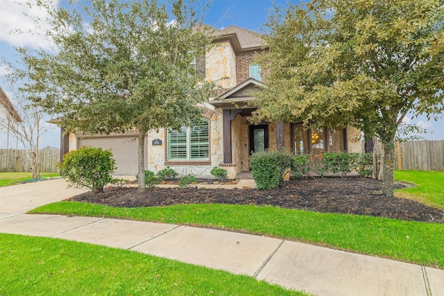 view of front of home featuring concrete driveway, an attached garage, fence, stone siding, and a front lawn