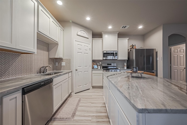 kitchen featuring recessed lighting, stainless steel appliances, a sink, visible vents, and white cabinets