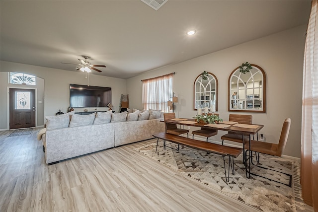 living room with a ceiling fan, baseboards, visible vents, and wood finished floors