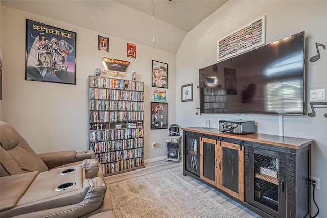 sitting room with lofted ceiling, light wood finished floors, and baseboards