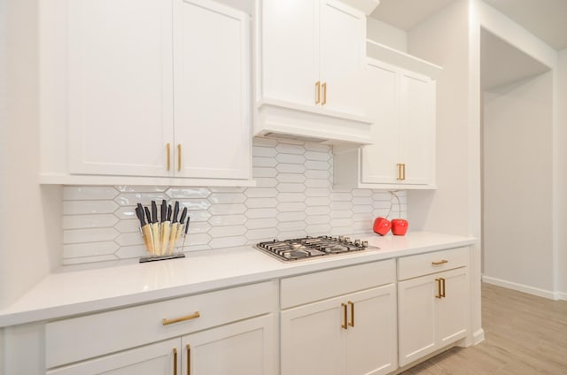 10711 Kingston Spring Dr, Missouri City, TX 77459 - kitchen with stainless steel gas stovetop, light countertops, and white cabinetry