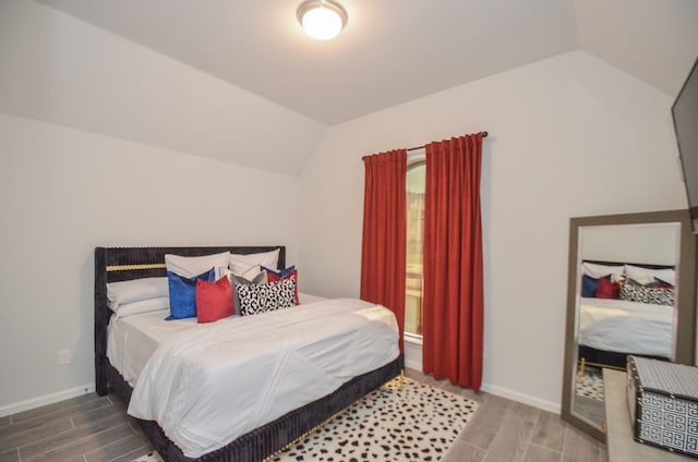 10711 Kingston Spring Dr, Missouri City, TX 77459 - bedroom with wood tiled floors, lofted ceiling, and baseboards