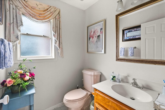 half bath featuring baseboards, toilet, and vanity