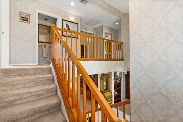 staircase featuring recessed lighting, visible vents, and wallpapered walls