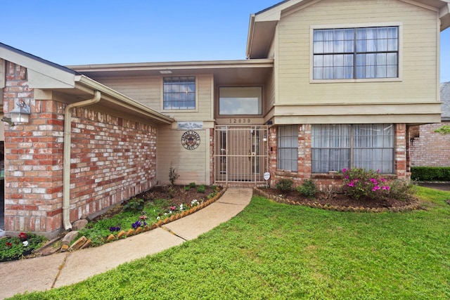 view of front of property with a front lawn and brick siding