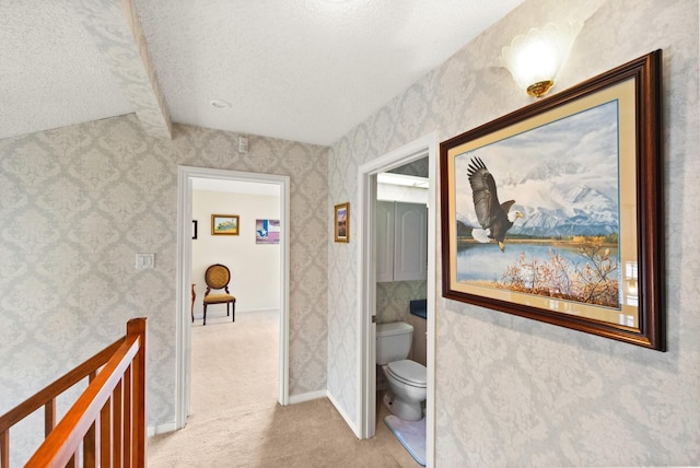 hall featuring baseboards, an upstairs landing, carpet flooring, and wallpapered walls