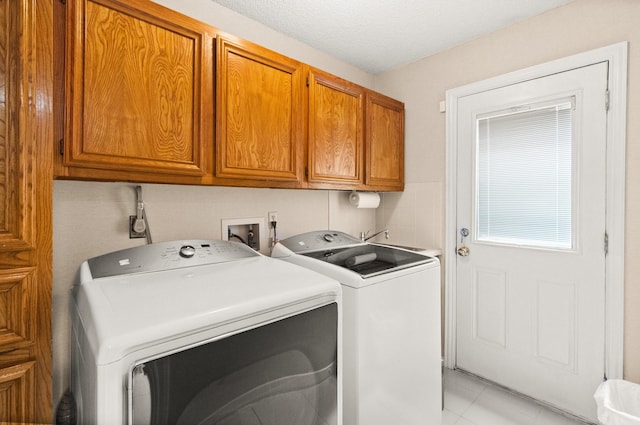 laundry room with cabinet space, separate washer and dryer, and a textured ceiling