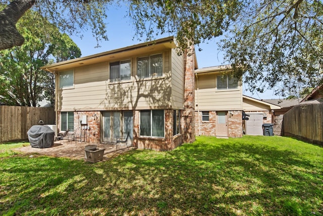 back of property featuring a patio area, a fenced backyard, brick siding, and a yard