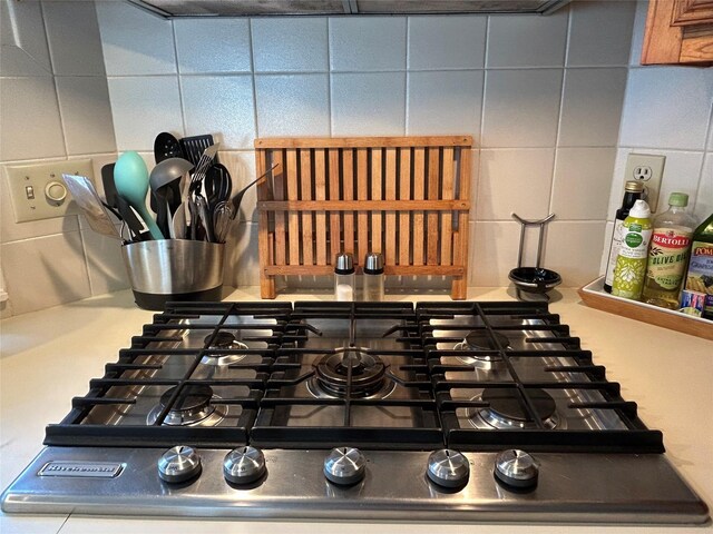 room details with range, backsplash, and stainless steel gas cooktop