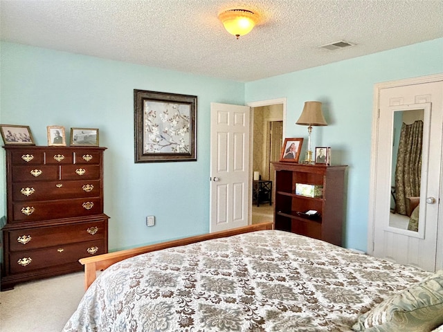 bedroom featuring light carpet, visible vents, and a textured ceiling