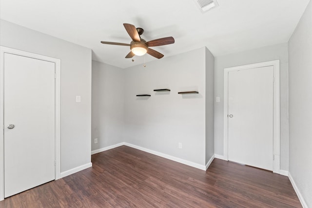 empty room featuring ceiling fan, wood finished floors, visible vents, and baseboards