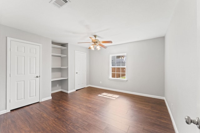 unfurnished bedroom featuring baseboards, visible vents, and dark wood-type flooring