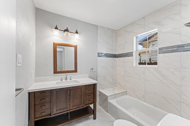 full bathroom featuring washtub / shower combination, marble finish floor, and vanity