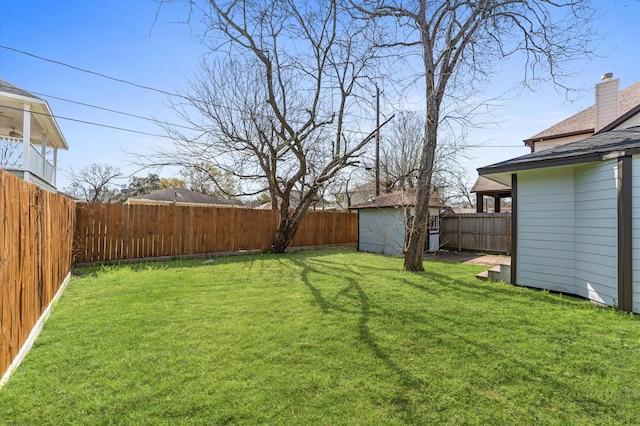 view of yard featuring a fenced backyard, an outdoor structure, and a storage unit