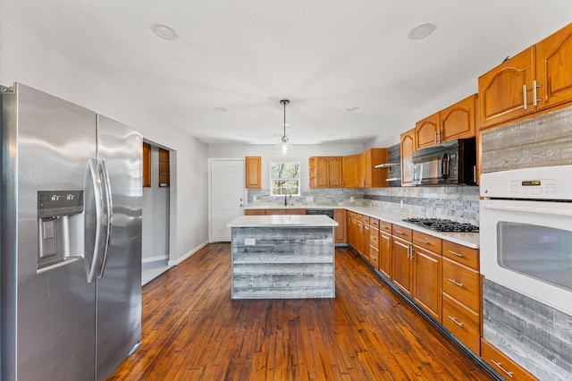 kitchen featuring dark wood-style floors, black appliances, backsplash, and light countertops