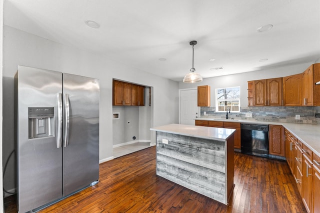 kitchen featuring dishwasher, stainless steel refrigerator with ice dispenser, brown cabinets, and decorative backsplash