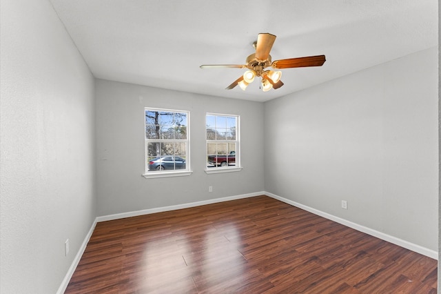 empty room with ceiling fan, baseboards, and wood finished floors