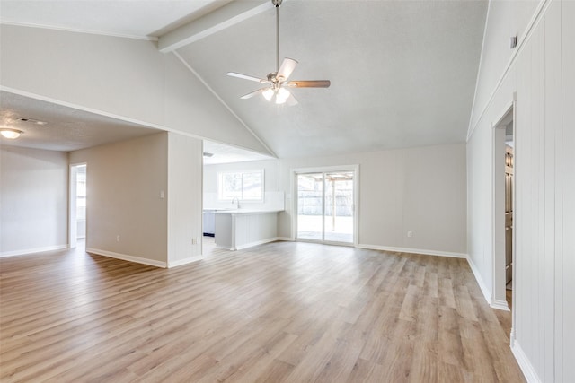 unfurnished living room with ceiling fan, light wood finished floors, a sink, and baseboards