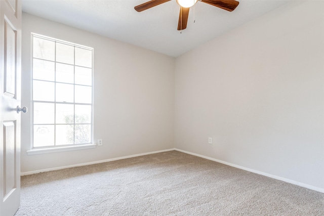 carpeted empty room featuring a ceiling fan and baseboards