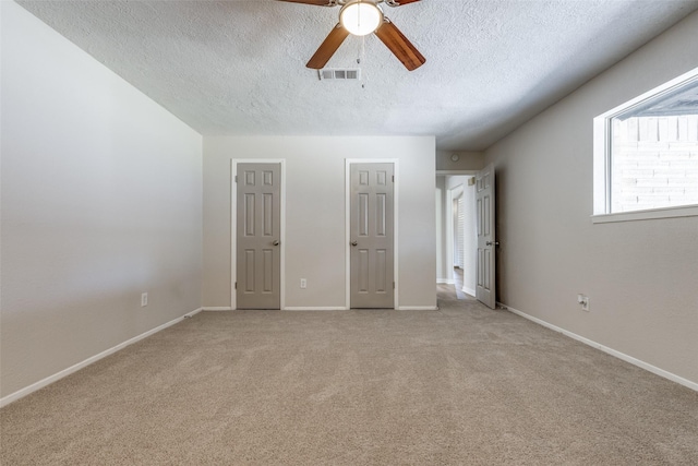 unfurnished bedroom with visible vents, carpet flooring, ceiling fan, a textured ceiling, and baseboards