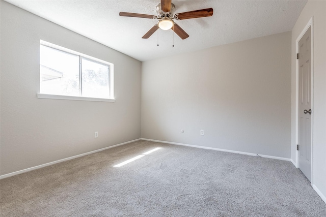 spare room with carpet, baseboards, and a textured ceiling