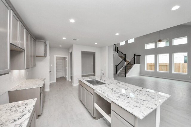 11926 Maple Oak Dr, Houston, TX 77066 - kitchen featuring ceiling fan, recessed lighting, light wood-style flooring, open floor plan, and light stone counters