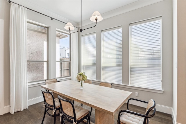 dining room featuring dark wood-style flooring, crown molding, and baseboards