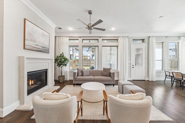 living room featuring visible vents, baseboards, dark wood-style floors, a premium fireplace, and ornamental molding