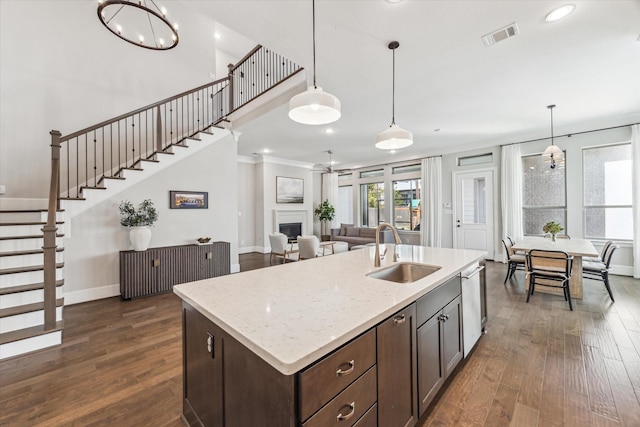 kitchen featuring a fireplace, visible vents, dark wood-type flooring, a sink, and dark brown cabinets